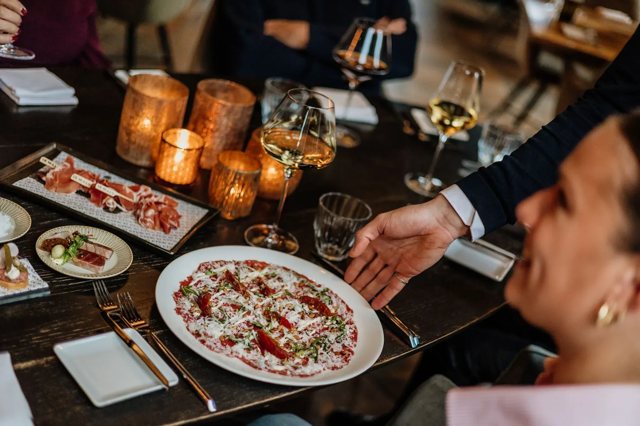 Carpaccio en charcuterie op een sfeervol gedekte tafel